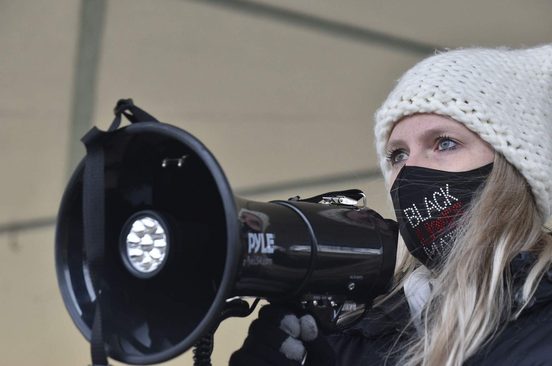 BCDR member Amy Krueger speaks into a megaphone, calling on Burlington to stand up to racism and for the Burlington Area School District to take the lead in that effort